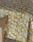 Yellow floral patterned tablecloth on a wooden chair