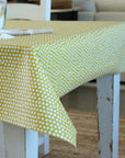 Table with a yellow and white polka dot tablecloth in an indoor setting.