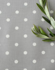 Gray oilcloth with white polka dots and green leaves on the right side