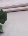 Close-up of striped oilcloth with a green leaf in the foreground