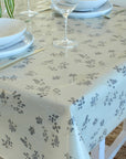 Table setting with floral-patterned tablecloth, plates, and wine glasses.