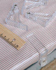 Clear plastic clips on a striped oilcloth with a wooden ruler for scale.