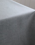 Gray green tablecloth draped over a table with a neutral background