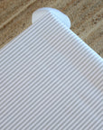 Ticking stripe oilcloth with a jute carpet background