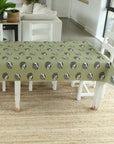 Tablecloth with hedgehog pattern on a dining table in a room with white chairs and a couch.