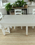 White table with a dotty patterned oilcloth in a living room setting