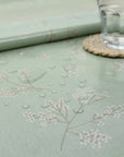 Light green tablecloth with floral patterns on a table