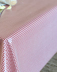 A red and white gingham checkered tablecloth draped over a table, with a knife and butter visible in the top-left corner.