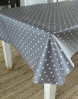 Gray tablecloth with white polka dots on a wooden table.