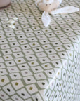 Tablecloth with geometric pattern on a table, featuring a soft toy.