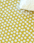 Oilcloth with white polka dots on a yellow background