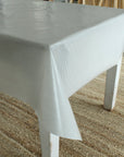 White and grey striped tablecloth on a table with a textured surface background