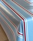 Close-up of a striped oilcloth with red, white, and blue lines on a wooden surface.
