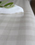 Close-up of an oilcloth with olive leaf and a white napkin.