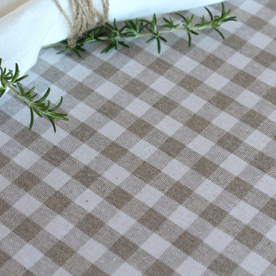 Checkered tablecloth with a sprig of rosemary on a white background