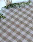 Checkered tablecloth with a sprig of rosemary on a white background