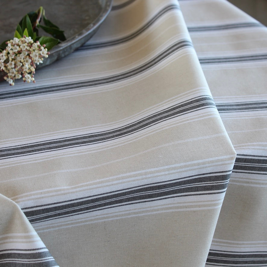 striped grey and beige tablecloth in sof folds on a table