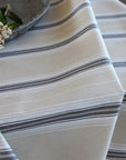 striped grey and beige tablecloth in sof folds on a table