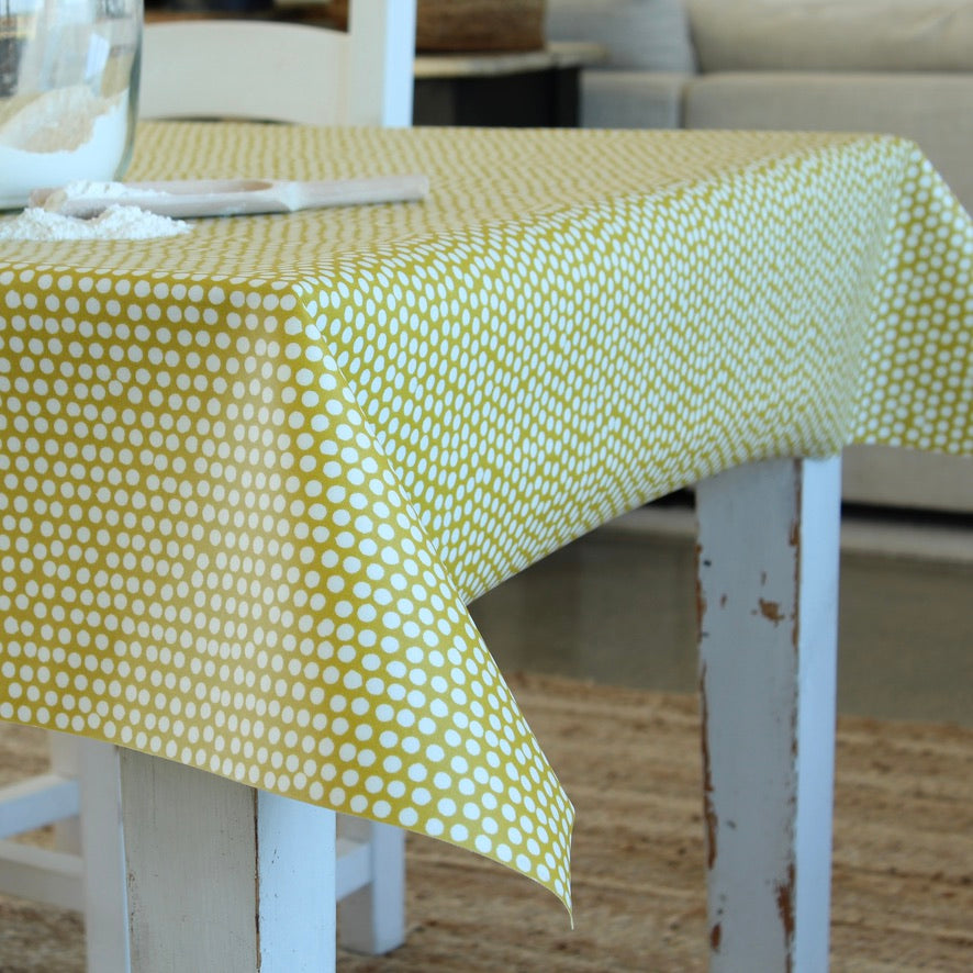 Table with a yellow and white polka dot tablecloth in an indoor setting.