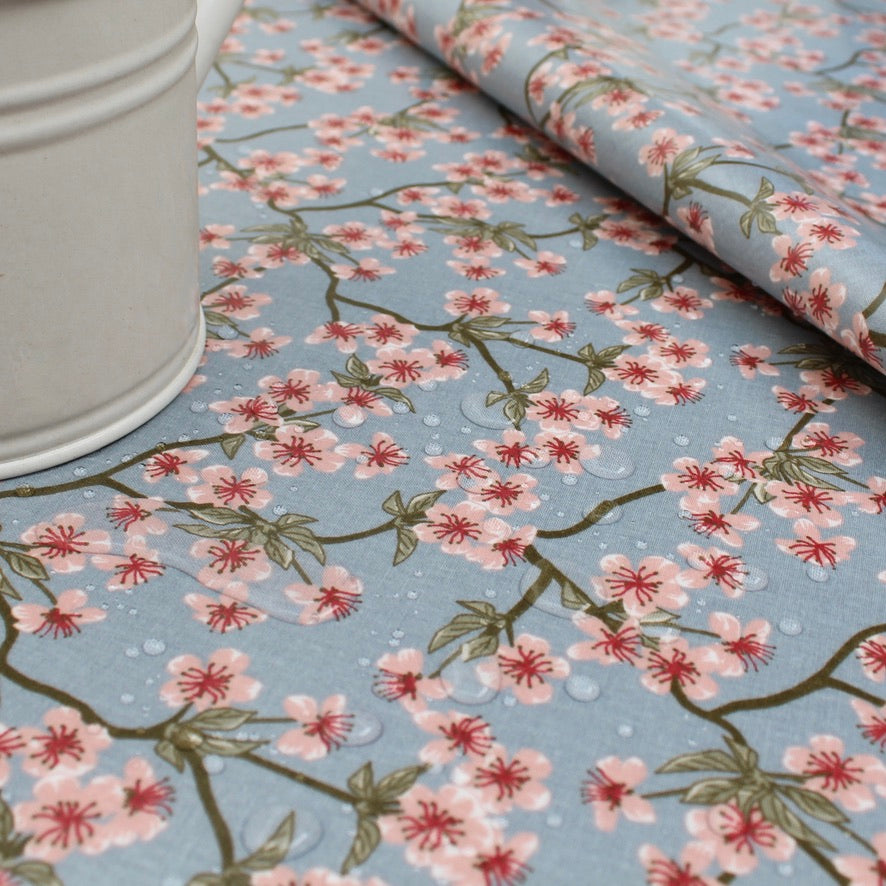 Floral oilcloth with cherry blossom pattern on a blue background