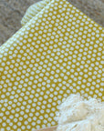 Yellow oilcloth with white polka dots and a small pile of flour