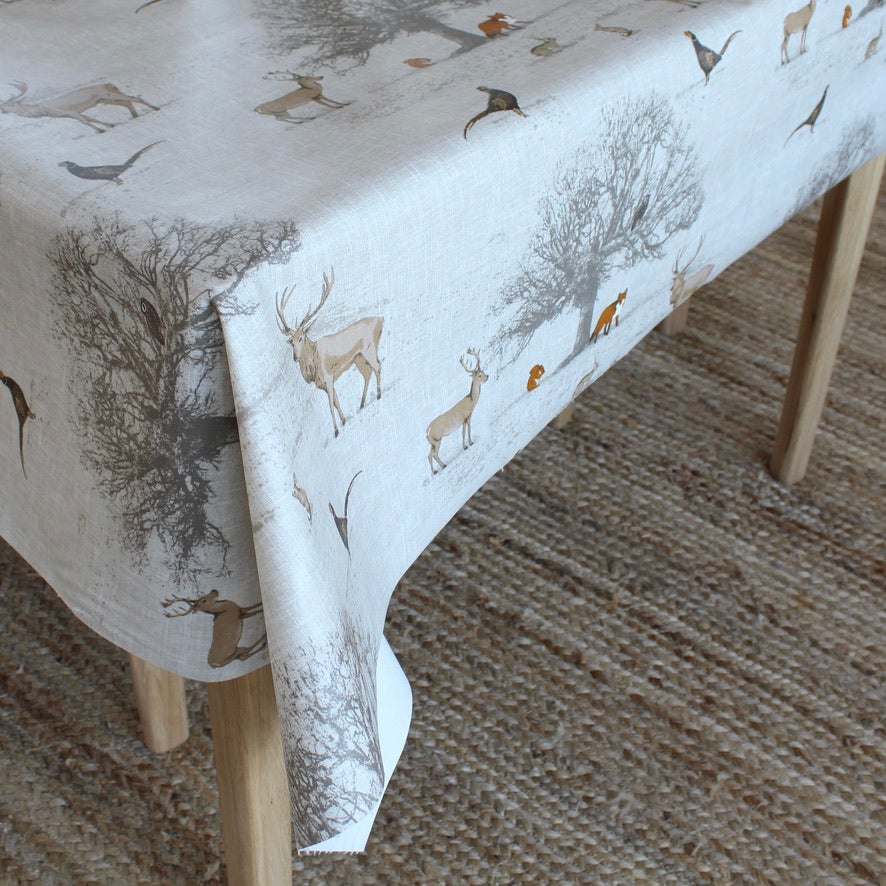 Tablecloth with deer and nature pattern on a wooden table