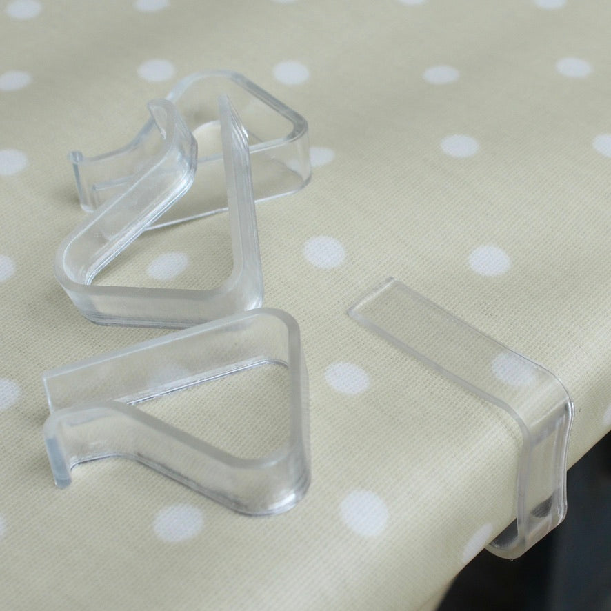 Clear plastic tablecloth clips on a polka dot fabric background