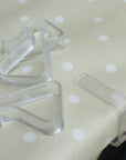 Clear plastic tablecloth clips on a polka dot fabric background