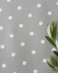Gray oilcloth with white polka dots and green leaves on the right side