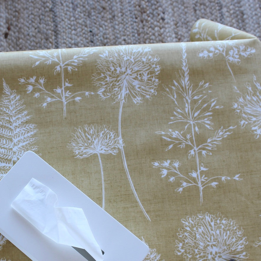Oilcloth with white floral pattern on a yellow background, with a white tissue box.
