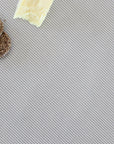 Crackers and a block of cheese on a striped tablecloth