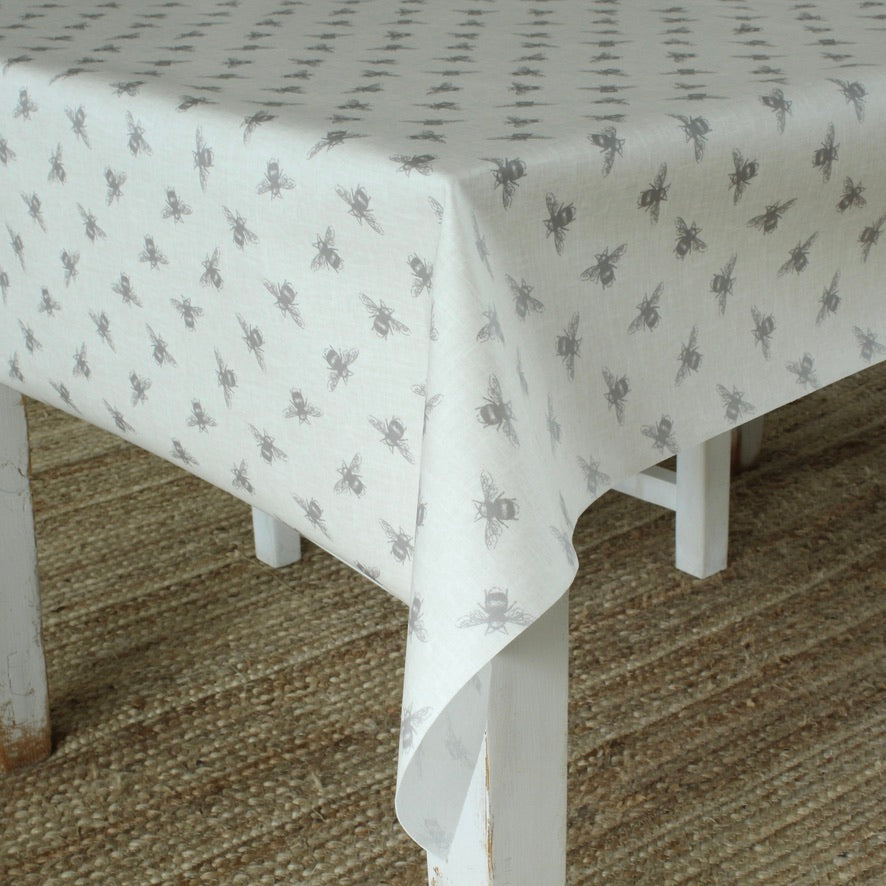 White tablecloth with gray bee pattern on a white table