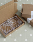 Clear plastic clips in a cardboard box on a polka dot surface