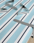 Metallic tablecloth clips on a blue and white striped oilcloth