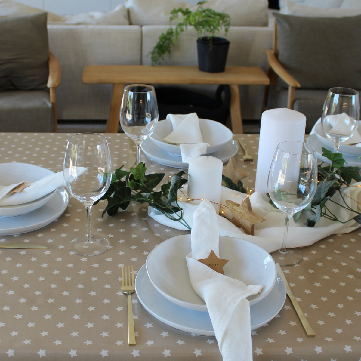 christmas theme table setting on a tablecloth with white stars and a beige background