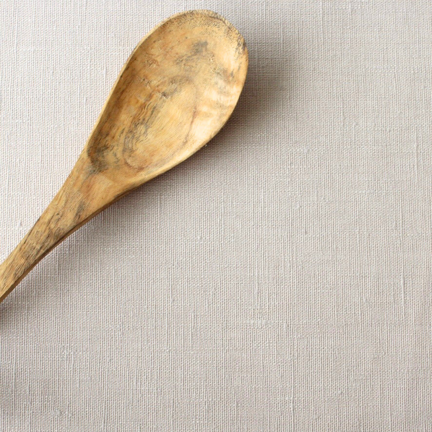 Wooden spoon on a beige linen tablecloth