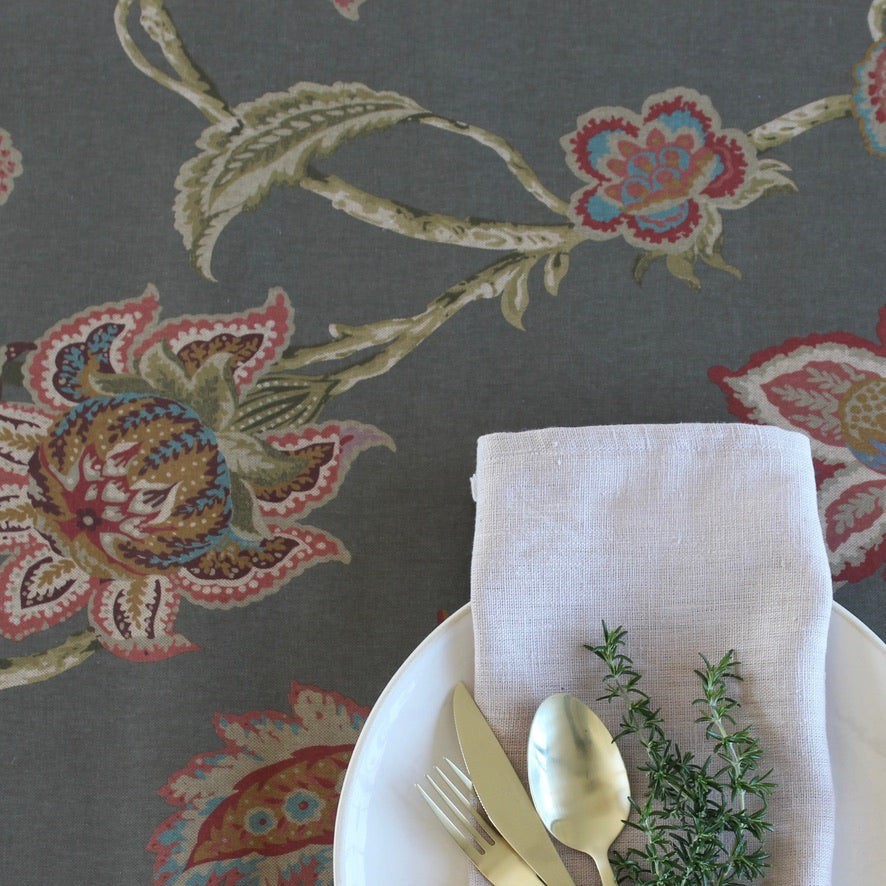 dark patterned floral tablecloth with gold cutlery and linen napkin