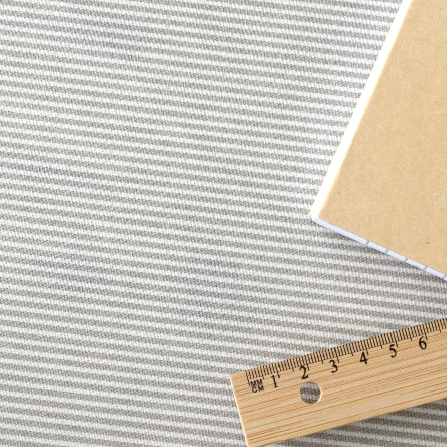 Striped oilcloth with a wooden ruler for scale on a white background