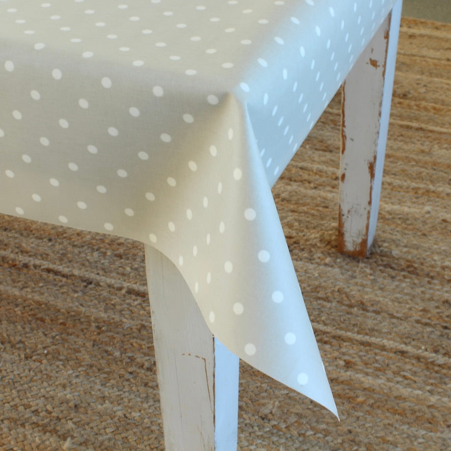White chair with a polka dot tablecloth on a textured surface