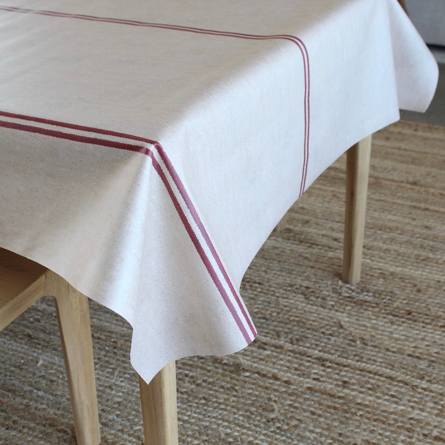 grain sack pattern tablecloth with red stripe on a wooden table