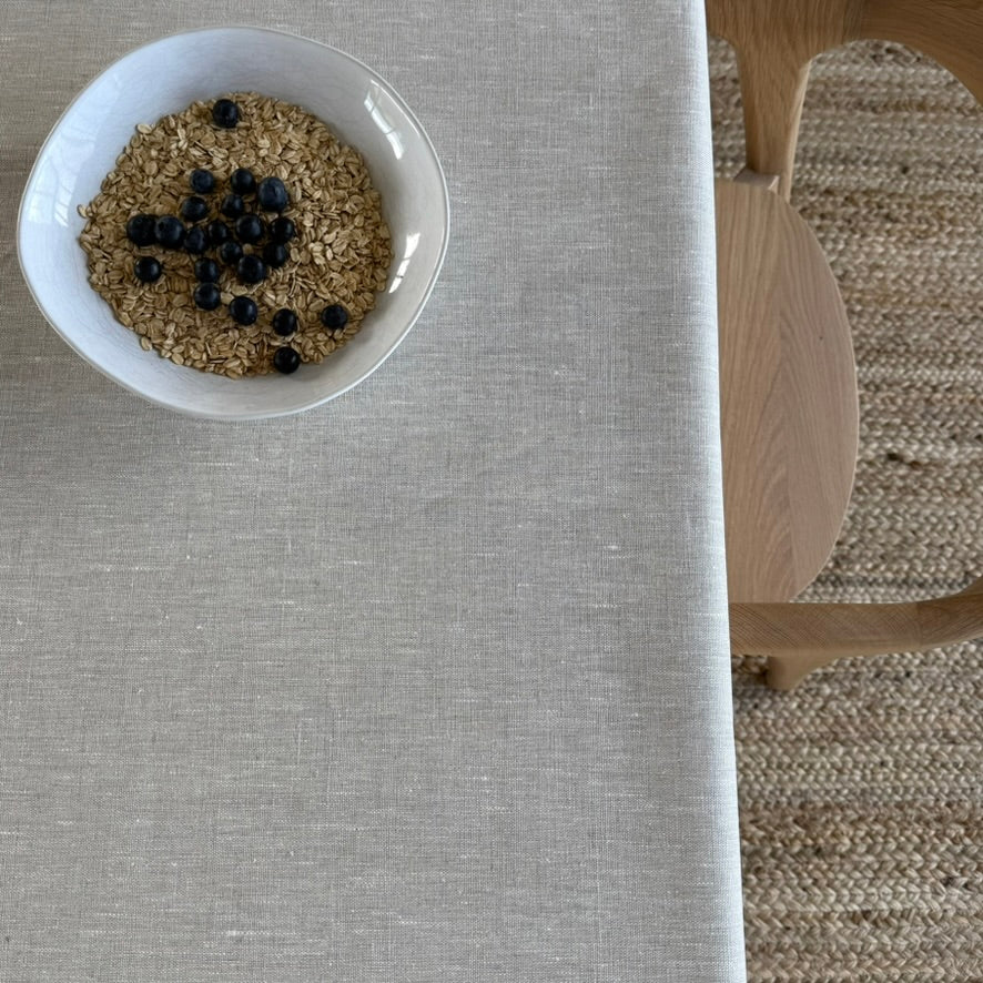Bowl of granola with blueberries on a beige linen tablecloth