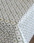 Close-up of a patterned oilcloth with small geometric shapes on a light green background