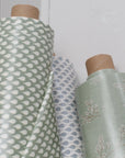 Three rolls of oilcloth with different patterns against a white wall.