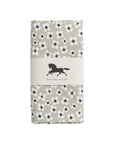 A folded oilcloth featuring a black and white floral pattern on a light beige background, wrapped in a neutral paper band with a black horse logo and the text 'Swedish design since 1849'.