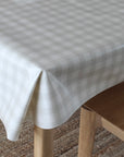 Checkered tablecloth on a wooden table with a chair