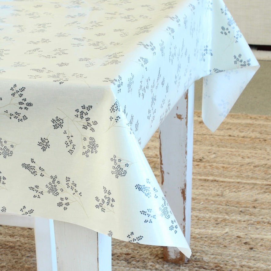 White tablecloth with black floral pattern on a wooden table.