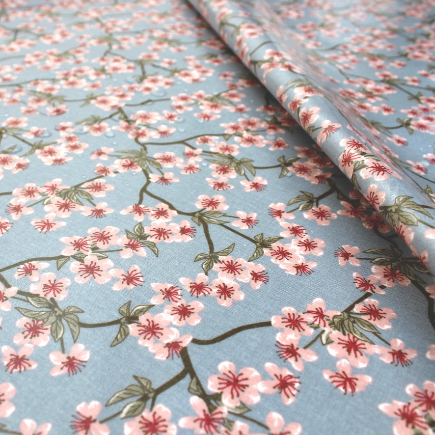 Floral oilcloth with cherry blossom pattern on a light blue background