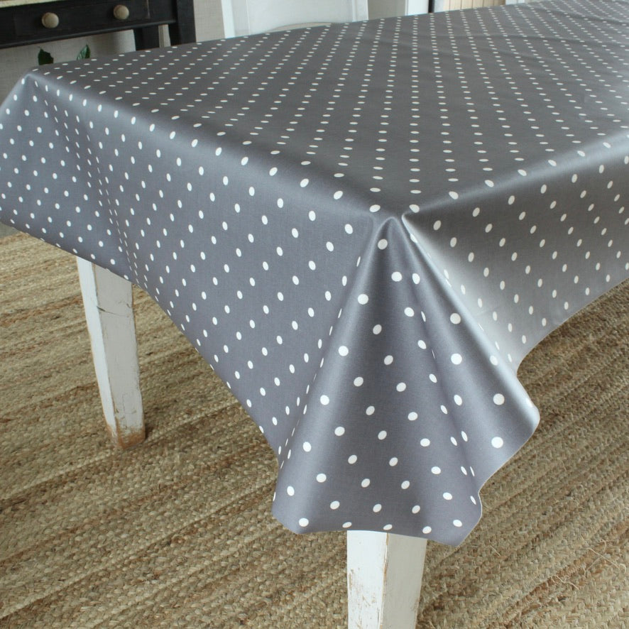Gray tablecloth with white polka dots on a wooden table.