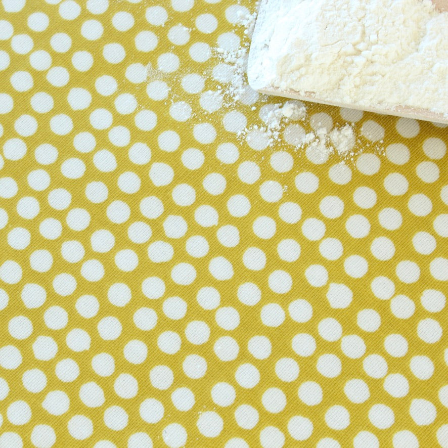 Oilcloth with white polka dots on a yellow background