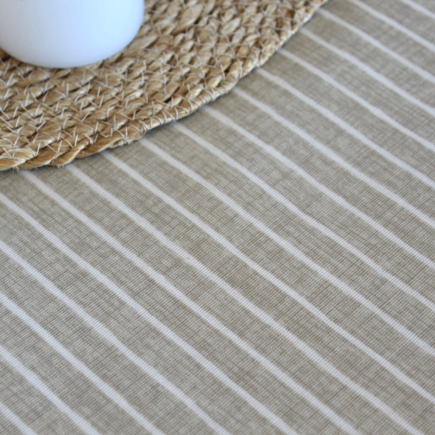 Close-up of an oilcloth with horizontal stripes and a woven mat.